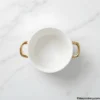 Top view of an empty ceramic soup bowl with gold handles