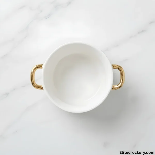 Top view of an empty ceramic soup bowl with gold handles