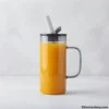 Glass mug filled with juice and straw