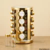 Golden rotating spice rack with glass jars on wooden table