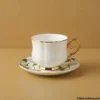White and Gold Tea Cup Set White and gold tea cup and saucer on table