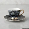 Single tea cup and saucer with tropical leaf design and gold handle