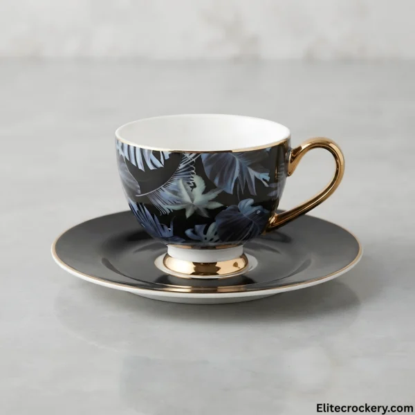 Single tea cup and saucer with tropical leaf design and gold handle