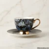 Luxury tea cup with gold rim on white marble background